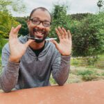 Portrait of an autistic man sitting on a park bench while using fidget spinners