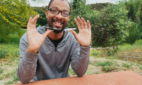 Portrait of an autistic man sitting on a park bench while using fidget spinners