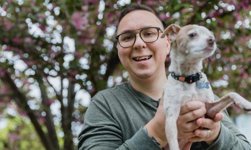 a man holding a small dog in his hands
